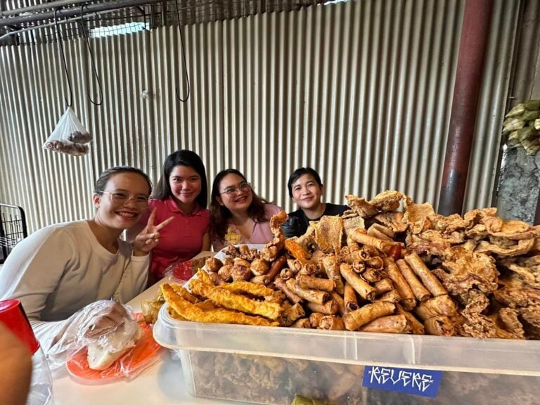 Friends seated behind trays of fried food at Pungko-Pungko sa Fuente in Cebu City