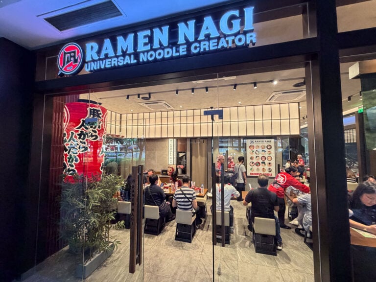 The lit blue Ramen Nagi storefront sign at Ayala Center Cebu with a red Japanese lantern and a full dining room behind the glass