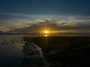 Aerial view of Bohol’s coastline at sunset with small boats anchored in calm water