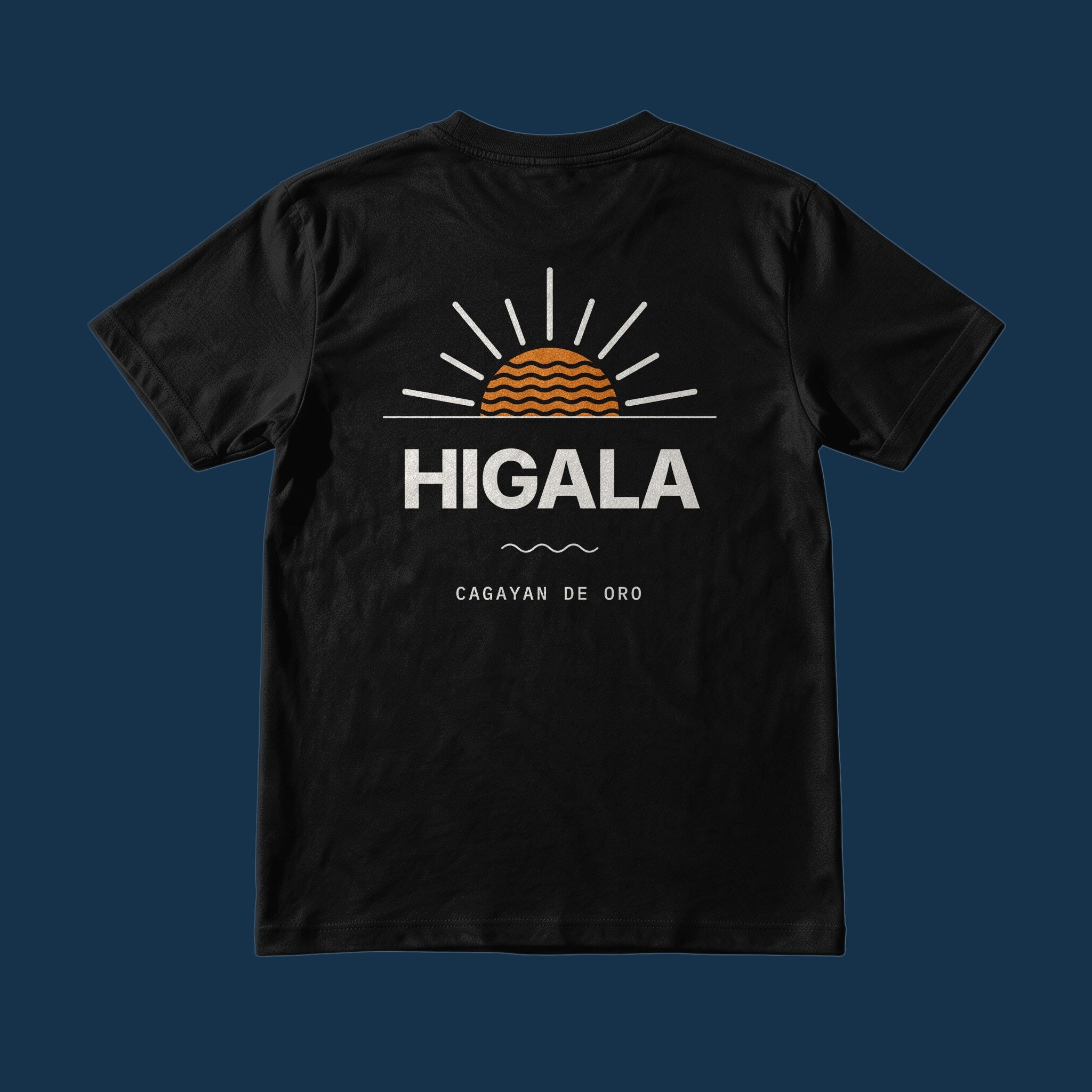 Suroy Wear Cagayan de Oro Higala Tee in Midnight Black, back view, HIGALA under an orange sunrise with Cagayan de Oro below