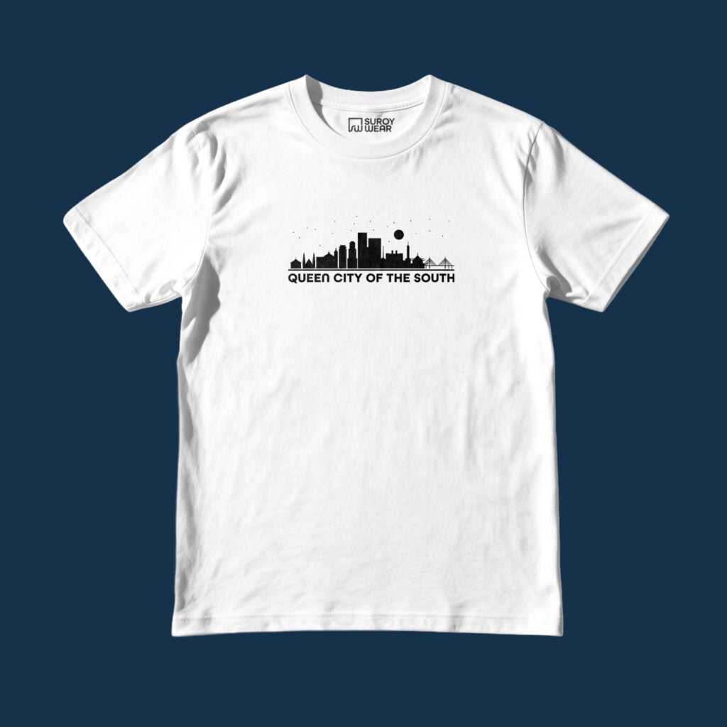 Suroy Wear Cebu Queen City Tee in white on a deep navy background, front view, black Cebu skyline and a moon printed above the words Queen City of the South