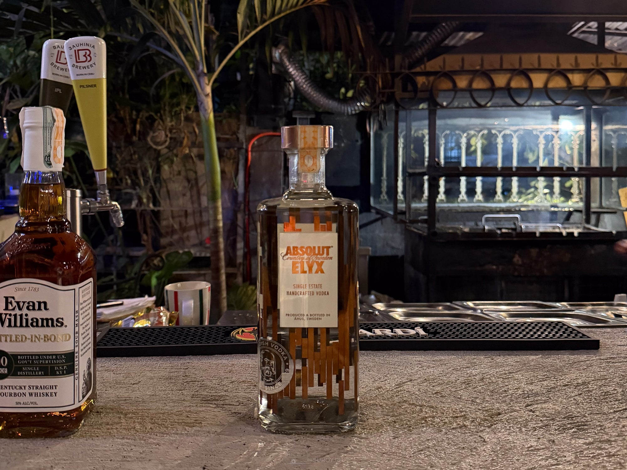 Bar counter at Balai at night with beer taps, Evan Williams bourbon and Absolut Elyx vodka