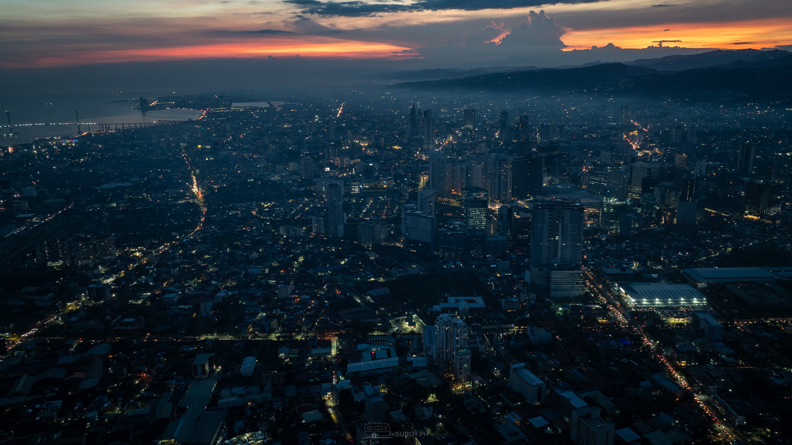 Aerial view of Cebu City at dusk with large unlit areas across the urban grid.