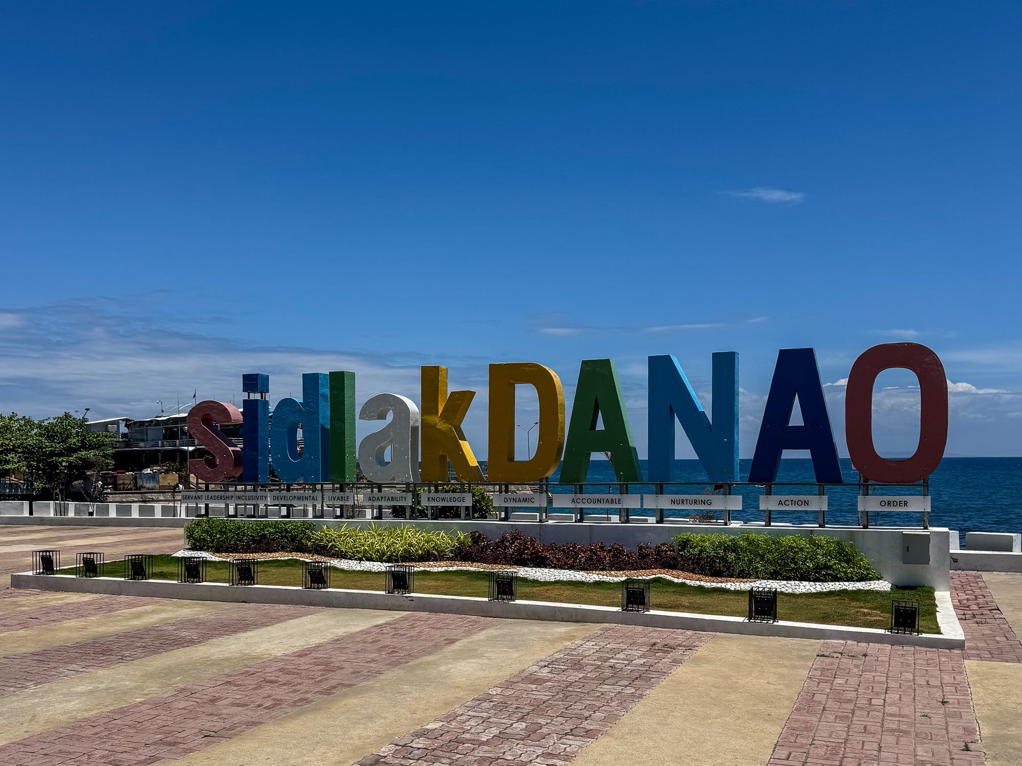 The colored Sidlak Danao letter sign on the seaside promenade at Danao City, with the sea behind it