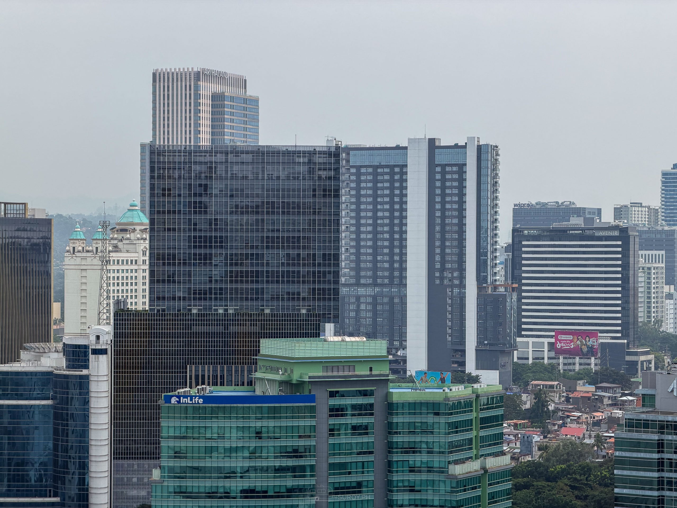 Cebu City business district towers under a flat white haze filled sky.