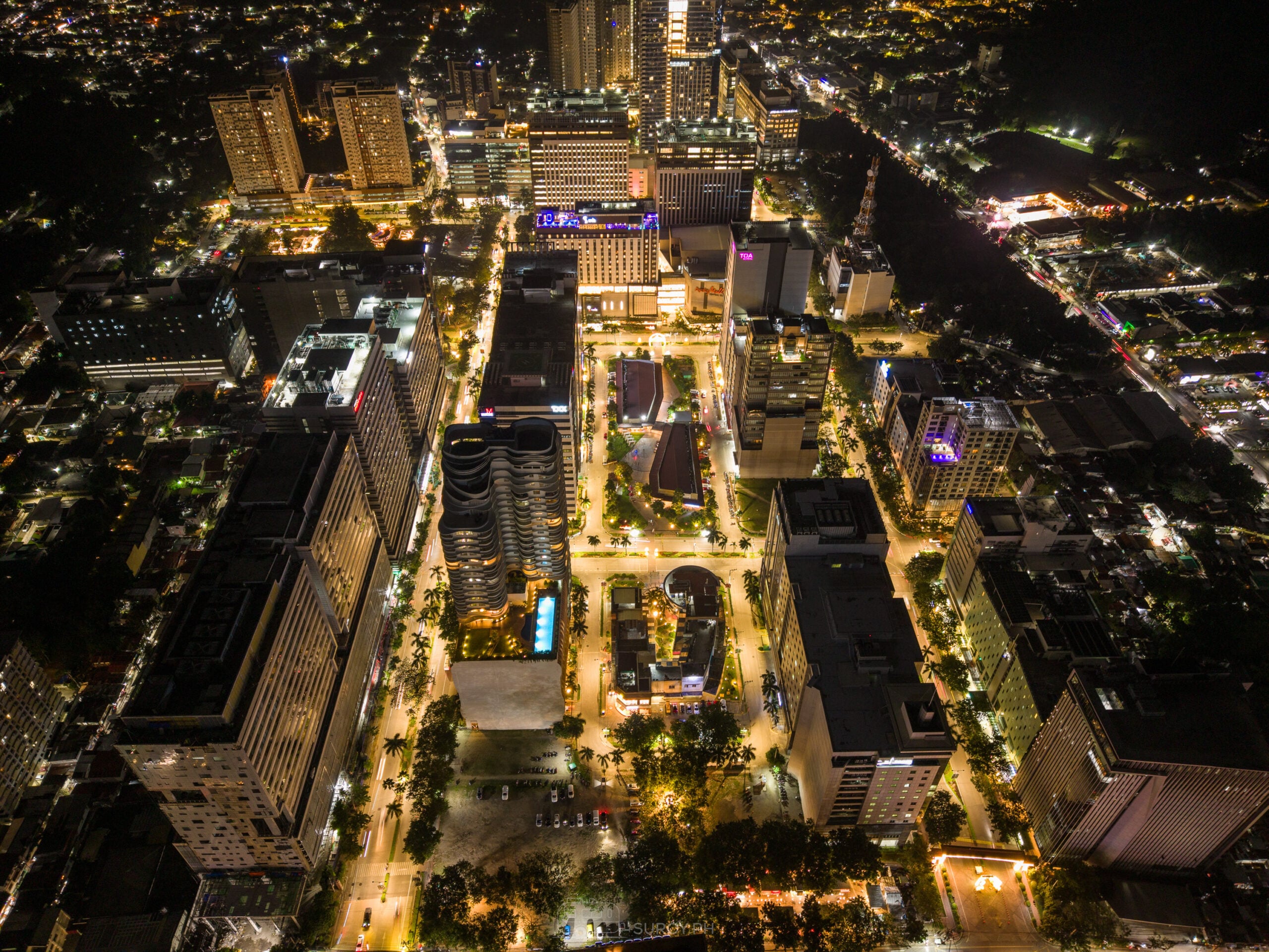 Wide night aerial of Cebu IT Park showing office towers, residential buildings and Ayala Malls Central Bloc