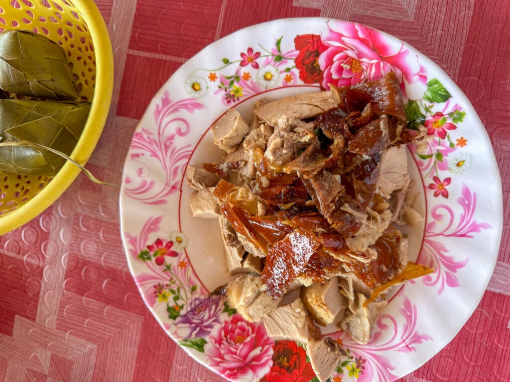 A plate of chopped Talisay lechon served with woven pusô rice pouches