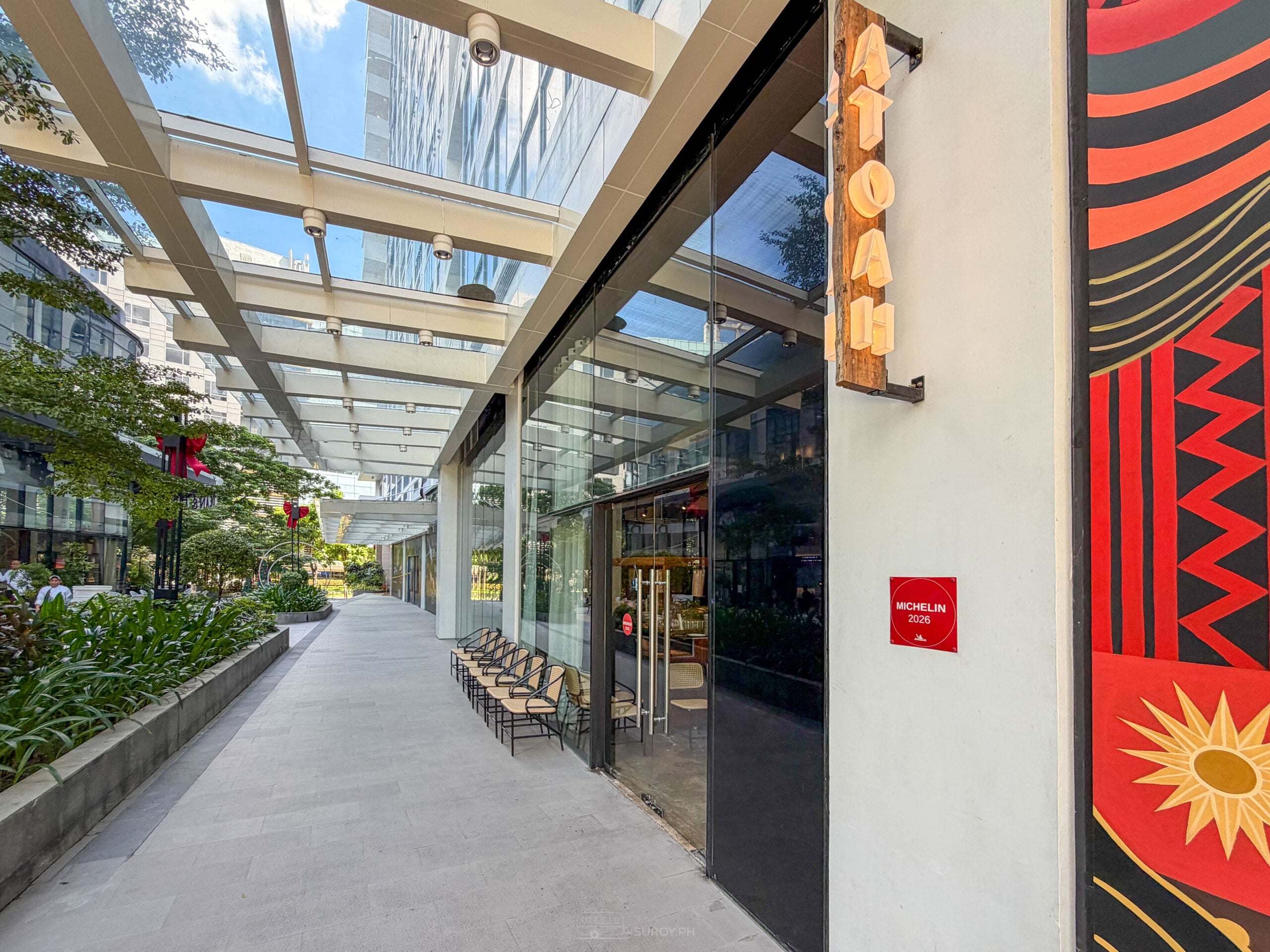 Covered walkway along Park Avenue in Cebu IT Park with the ATO-AH glass frontage and a red patterned panel