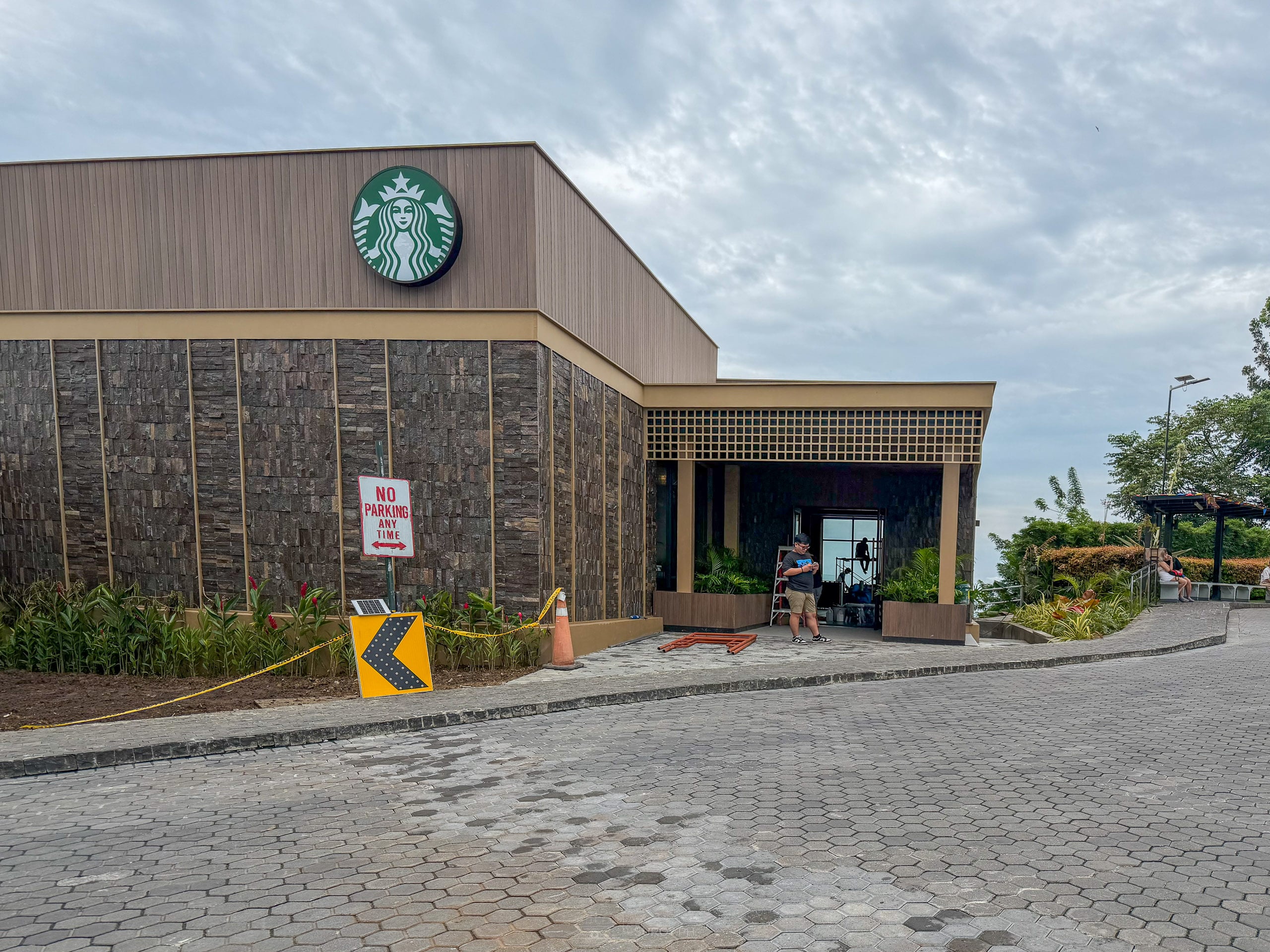 Front of the Starbucks pavilion at Tops with its glass entrance, potted plants and a no entry sign before opening